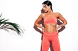 © halayalex - Tanned fitness woman in pink sports clothing. Sexy young beautiful model with perfect body.Female isolated on white background in studio. Stretching out before training. Near wall.