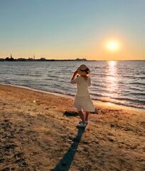 Wall Mural - woman on white dress watching pink sunset on beach at sea romantic nature landscape seascape 