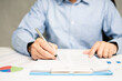 © Mdisk - professional businessman hand holding pen writing and sign paperwork or document finance indoor at office, man manager person handwriting paper on clipboard and signature agreement approval business