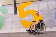 © unai - A disabled person in a public park in a wheelchair, wearing a yellow t-shirt
