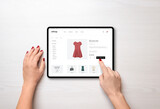Fototapeta Nowy Jork - Online shopping with a tablet. Red women's dress on the e-commerce web page