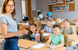 © Iryna - Female teacher with children at class. Educated kids, education concept.