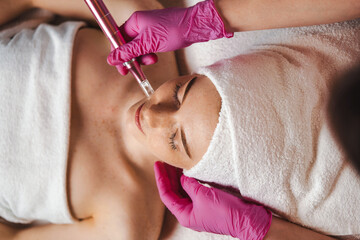 Wall Mural - top view of a woman getting facial mesotherapy treatment by professional dermatologist. skin beauty 
