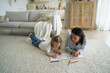 © VK Studio - Mother, little daughter paint together lying on floor in living room. Child creativity, parenting