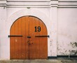 Front view of a wooden door with a number 19 on a pink dirty wall