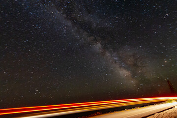 Wall Mural - milky way galaxy with road car light streaks (long exposure)