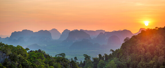 Wall Mural - Mountains sunset panorama landscape with dramatic sunset mountain, tropical forest and mountain ridge on horizon. Krabi, Thailand