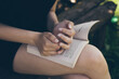 Young lady reading book, hands and open pages close up