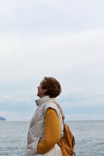 Happy Mature Woman In Yellow Clothes Is Standing Near Sea