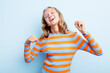 Caucasian teen girl isolated on blue background celebrating a special day, jumps and raise arms with energy.