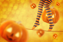 Women's Legs In Striped Stockings On A Halloween Holiday Background
