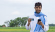Young Indian farmer with smartphone and debit card