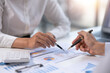 © amnaj - Close-up view of businessman analyzing graphs and organization chart  explain to the meeting the future business trends in the organization.