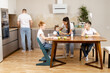 © Andrey Cherkasov - the child eats an apple at the kitchen table, the whole family is around