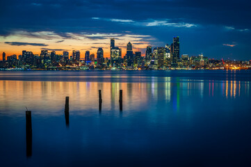 Wall Mural - Seattle Skyline During the Morning Blue Hour Seen From West Seattle.  Dynamic view of the Seattle cityscape just before dawn with Elliott Bay in the foreground and the waterfront in the distance. 