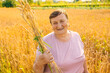 © Ivan - Smiling grandmother in a wheat field holding sheaf of wheat ears at wheat field.