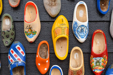 Koog Aan De Zaan, Netherlands. July 2022. Colorful Clogs Against The Background Of A Wooden Wall. Popular Souvenirs. Traditions Of Holland.