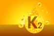 Vitamin K2. Golden drops with oxygen bubbles. Health concept