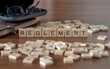 © lexiconimages - règlement mot ou concept représenté par des carreaux de lettres en bois sur une table en bois avec des lunettes et un livre