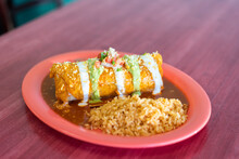 Delicious Mexican Food Burrito Chimichanga On Plate With Rice And Beans