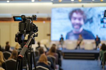 Camera shooting business conference in auditorium