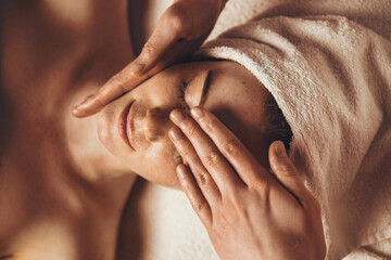 Wall Mural - top view of smiling freckled woman relaxing during myofascial massaging therapy at spa salon. face m