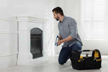 Wall Mural - Man installing electric fireplace near white wall in room