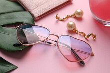 Stylish Elegant Heart Shaped Sunglasses And Earrings On Pink Background, Closeup