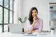 © Phushutter - Female business woman Asian people sitting at working desk, looking camera.