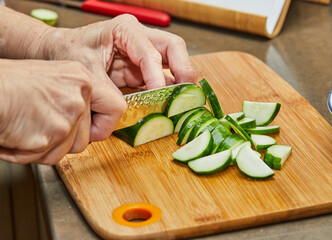 Wall Mural - Chef cuts the zucchini into semicircles to prepare the dish