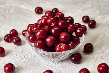 Wall Mural - red ripe cherries in a glass cup on the table