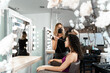 © carles - Profile of a hairdresser working on a woman in a beauty salon