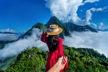 Women Tourists Holding Man's Hand And Leading Him To Pha dang Viewpoint In Muang Ngoy, Laos.