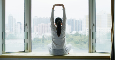 Canvas Print - Woman do Stretching exercises and sit in front of the window