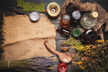 Herbal medicine concept background. Dry natural ingredients and remedy bottle on the wooden table background with copy space. Top view.