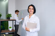 © Julia Jones - A female manager in the office against the background of a working team