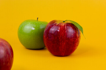 Wall Mural - Red and green apples isolated on yellow background. Two fresh apples fruits usedd for healthy food concept and for diet apples