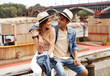 Leinwandbild Motiv Photo of young smiling couple embracing outdoor wear summer hat