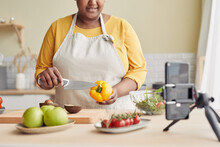 Closeup Of Young Black Woman Cooking Healthy Meal In Kitchen And Recording Video With Smartphone, Copy Space