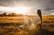 © shine.graphics - Christian woman holds bible in her hands. Reading the Holy Bible in a field during beautiful sunset. Concept for faith, spirituality and religion. Peace, hope