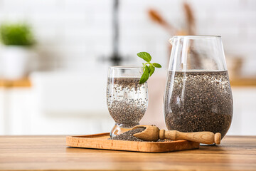 Wall Mural - Glass of water, jug, scoop and board with chia seeds on table in kitchen