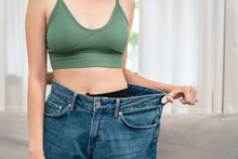 Sporty Woman Is Smiling While Wearing In Loose Big Jean To Showing Successfully Of Weight Loss