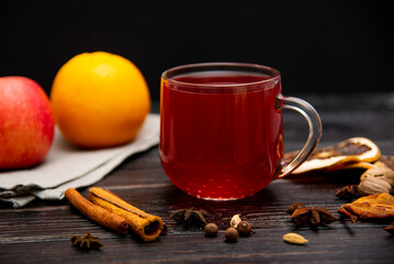 A mug of fruity red tea on a wooden background.