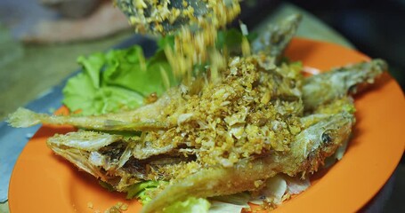 Wall Mural - Close up thai food deep fried crispy fish with garlic in plate at the kitchen