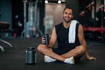 Wall Mural - Fitness Nutrition. Black Athlete With Sport Shaker Bottle And Whey Powder Container