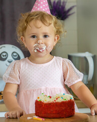 Poster - Child is two years old with a cake and candles. Selective focus.