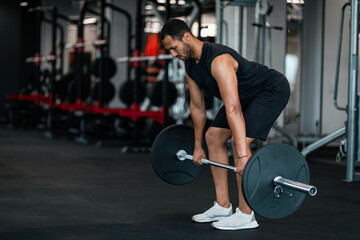 Wall Mural - Sporty Black Man Lifting Heavy Barbell While Training At Gym