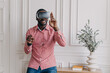 © VK Studio - Excited cheerful african man wearing VR glasses totaly immersed in augmented reality of 3d games