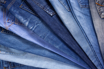 Wall Mural - Blue jeans denim heap background. Jeans fabric stack as material surface