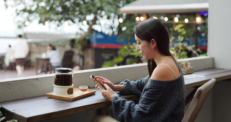 Wall Mural - Woman look at mobile phone in open area cafe